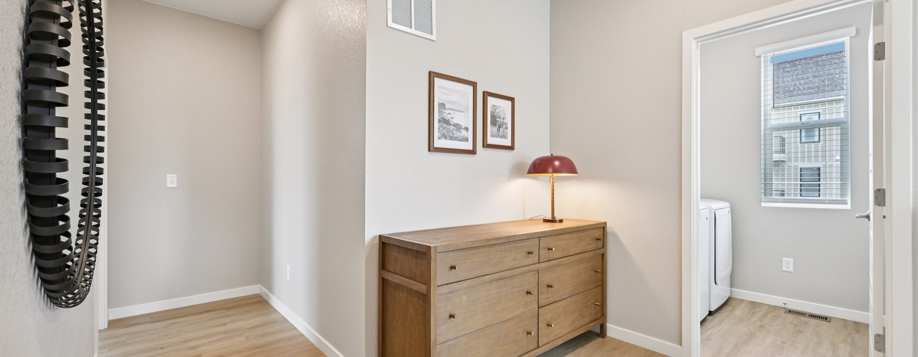 A hallway with a laundry room in a 3 bedroom house for rent in Aurora, CO at The Madison & Fillmore at Copperleaf.