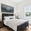 a bedroom with a bed, two nightstands and a chair